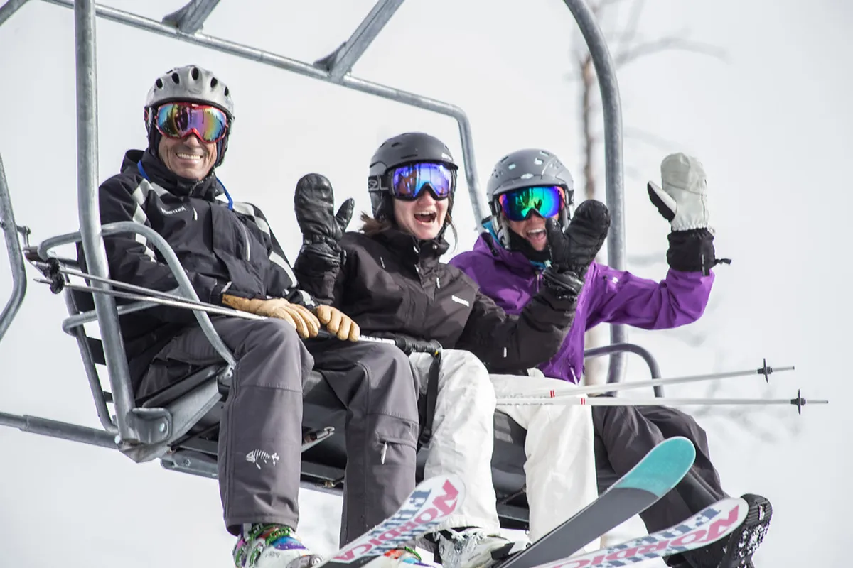 This exterior image shows a lively ski lift with skiers gearing up and enjoying the snowy landscape around them. The bustle of activity in the crisp mountain environment highlights the accessibility to skiing and snowboarding just steps from the property.